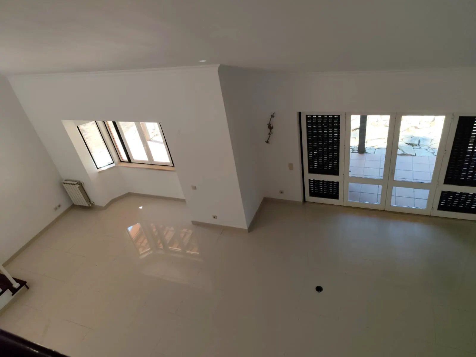 Sala ampla com paredes claras e pavimento brilhante