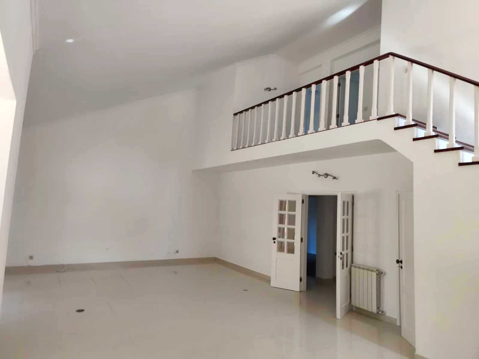 Sala ampla renovada com portas interiores brancas