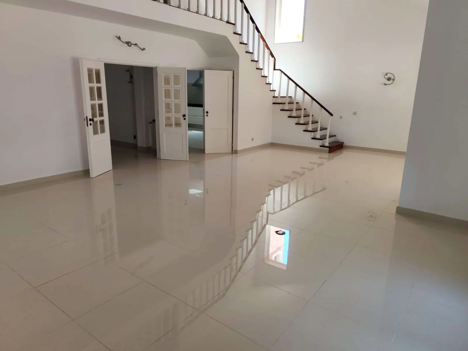 Sala com escada e chão cerâmico polido