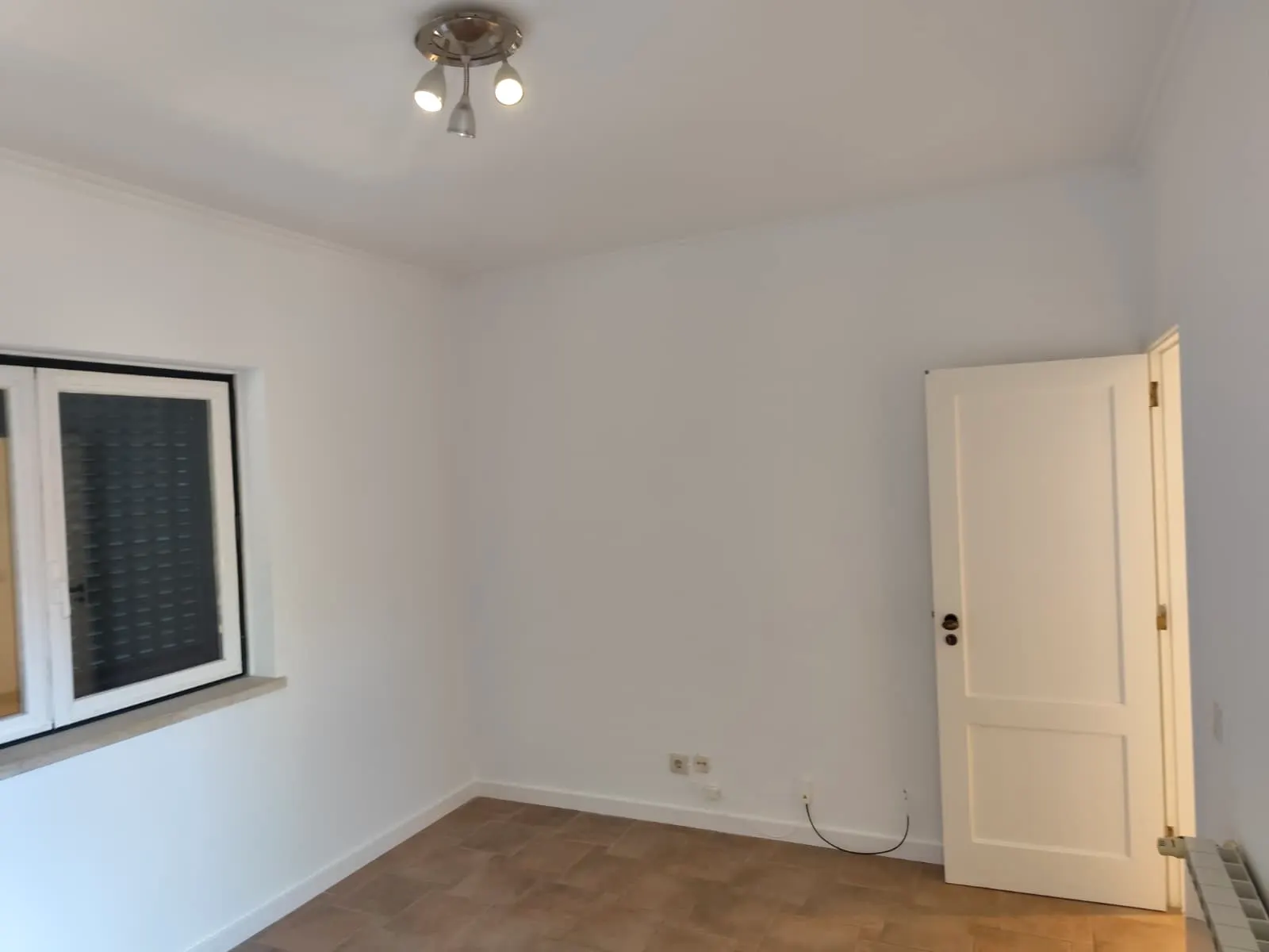 Quarto renovado com teto e paredes brancas