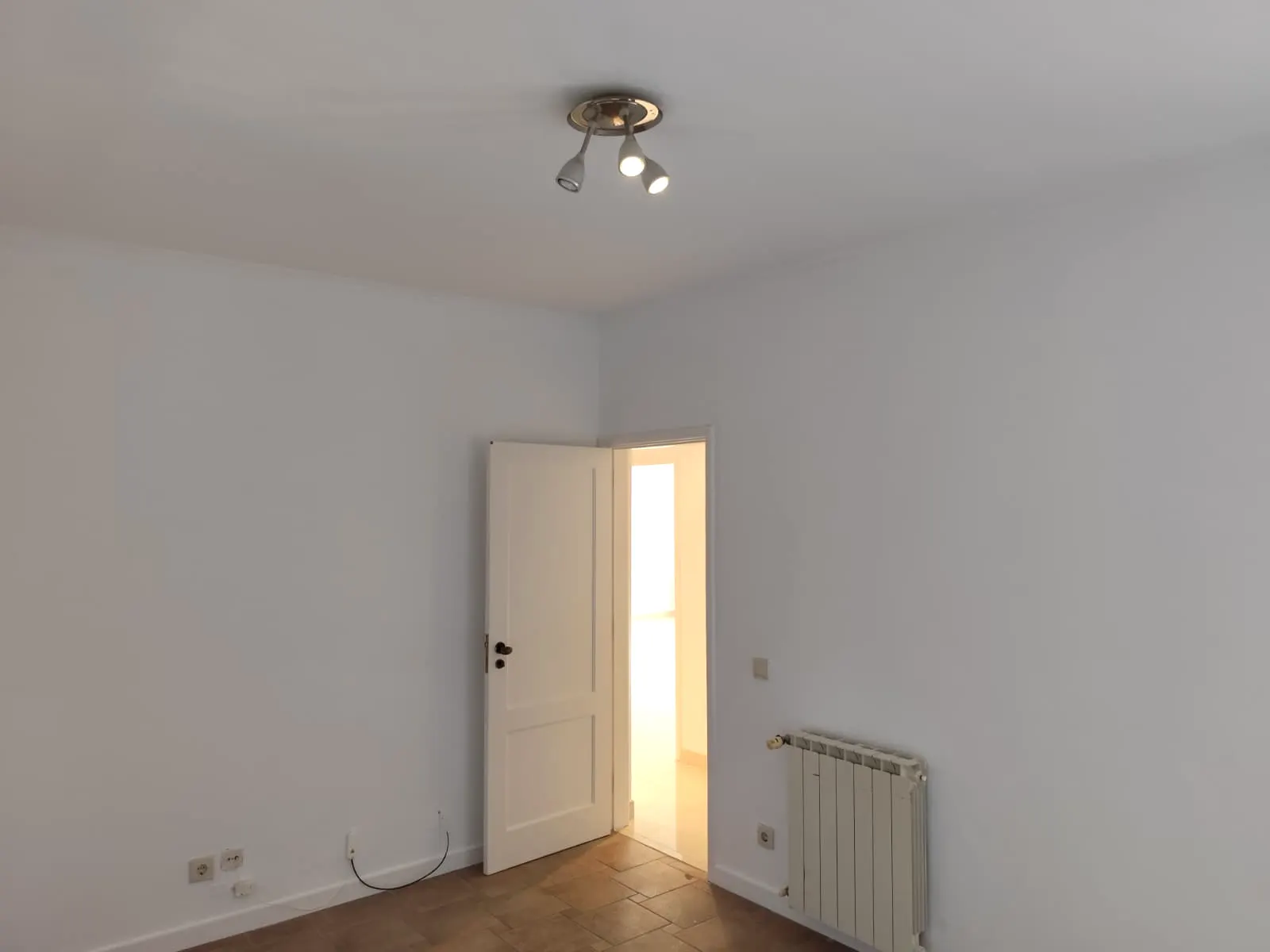 Quarto com radiador e porta interior branca