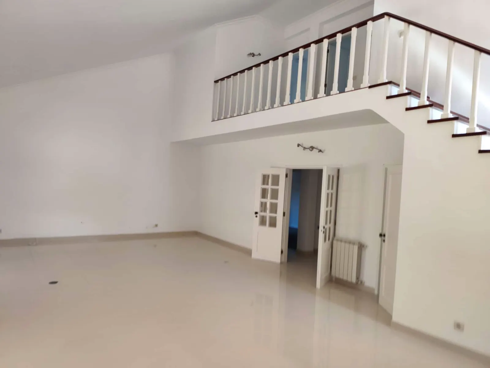 Sala ampla e mezanino com pintura branca